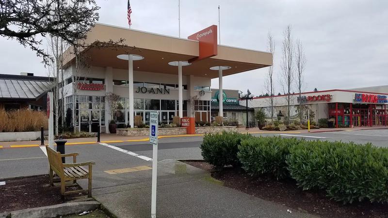 West entrance of Crossroads Bellevue, with the mall sign and a row of flags.