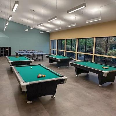 The games room at Crossroads Community Center, with foosball and air hockey tables and orange chairs.