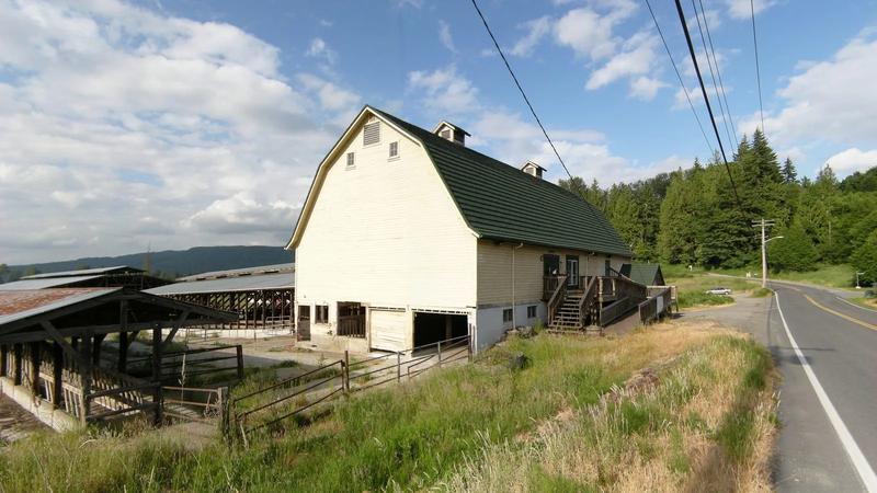 Cherry Valley Farms in Duvall, a white farmhouse and a red barn in green fields.