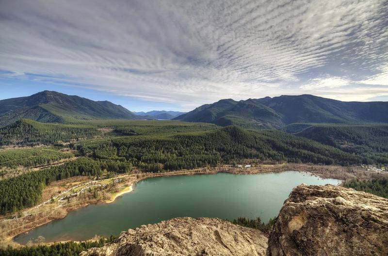 Rattlesnake Ledge above Rattlesnake Lake, with the cliff in the foreground and the lake and forest below.