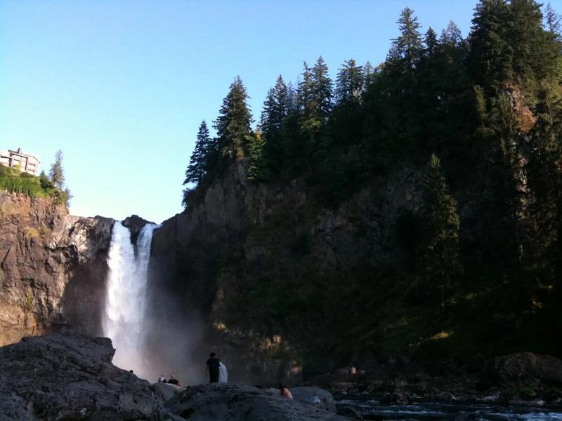 Snoqualmie Falls, a wide waterfall dropping into a gorge with mist at the bottom.