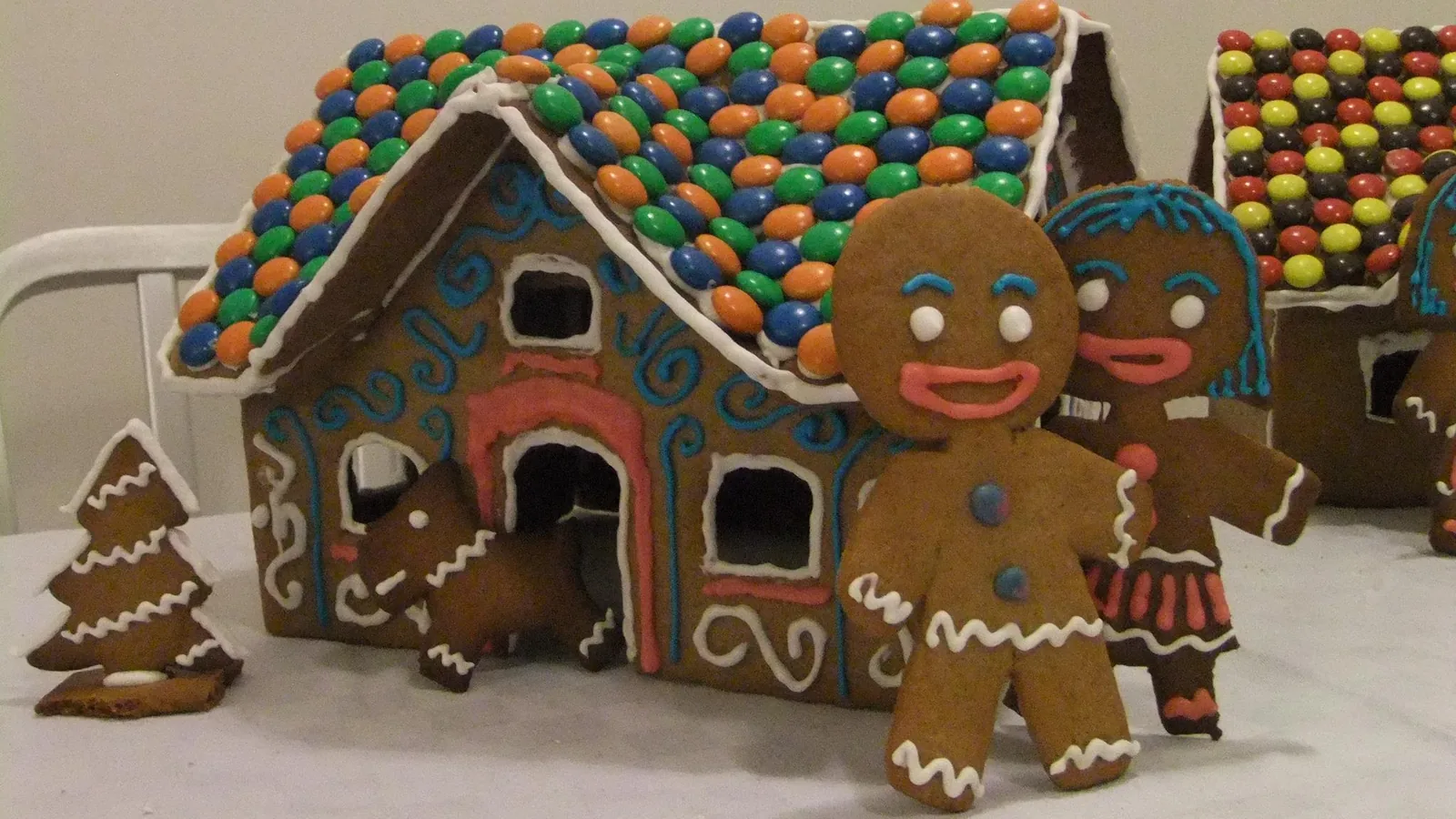 A gingerbread house decorated with white icing and candy.