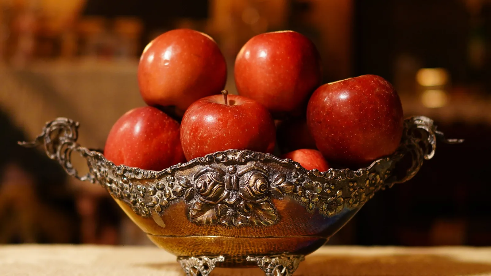 Red apples in a silver bowl.