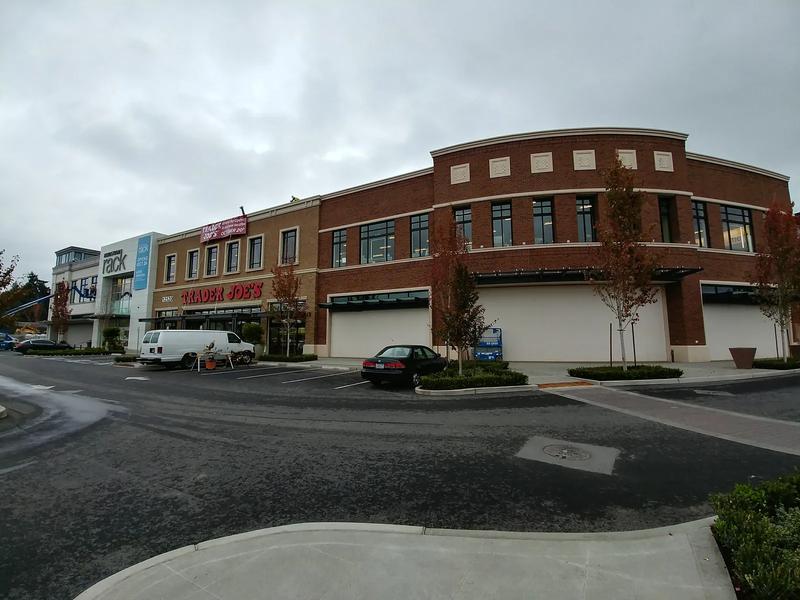 The Village at Totem Lake in Kirkland, with storefronts and fall trees along the walk.