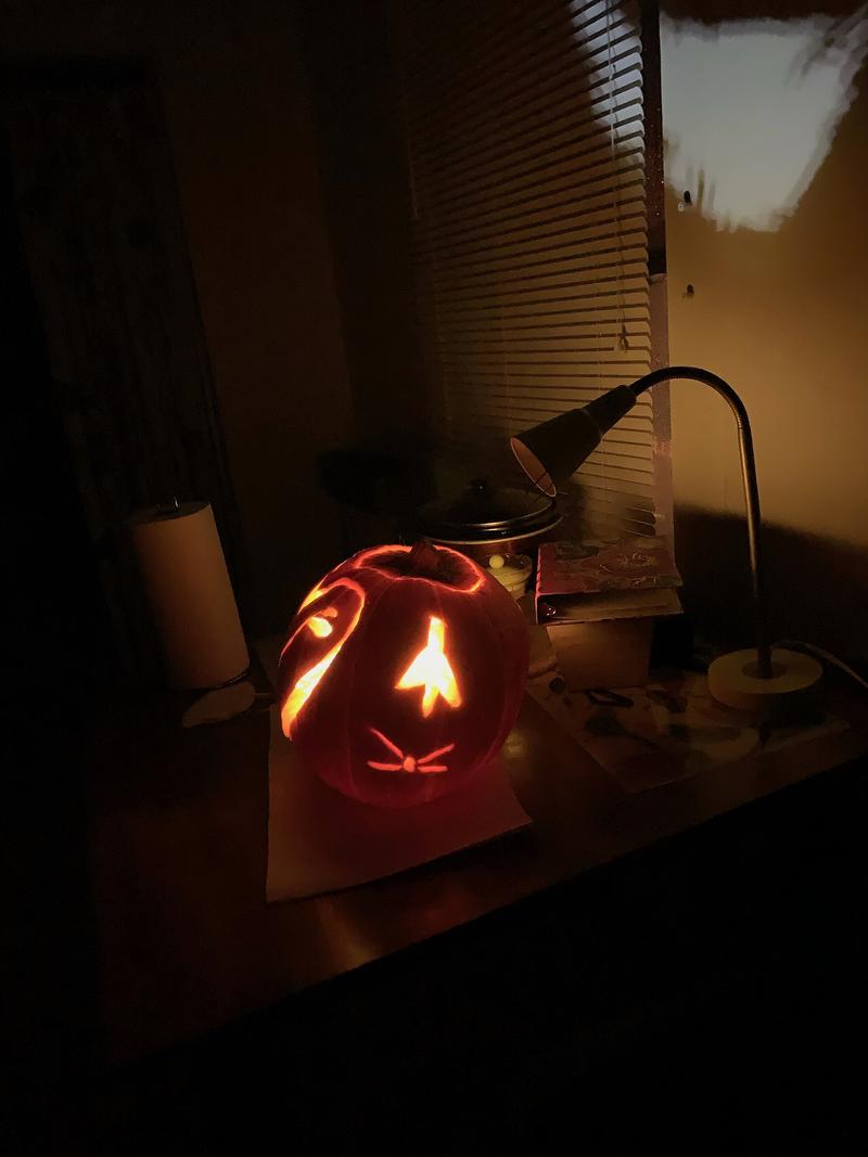 A jack-o-lantern carved in the shape of a barn owl.
