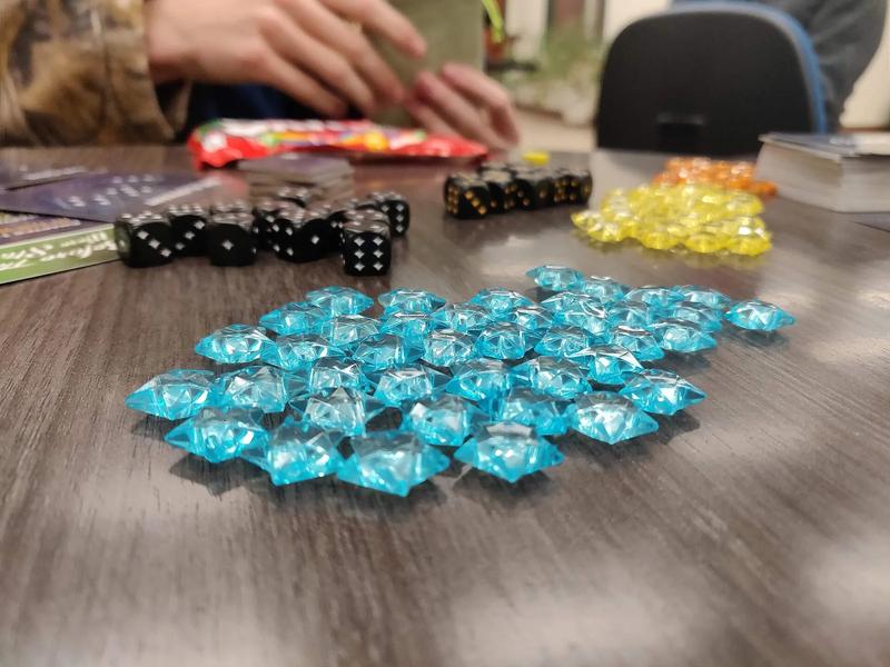 Small wooden and colored pieces from a board game.