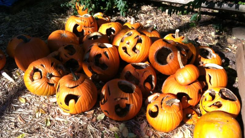 A jack-o-lantern in a small graveyard display.