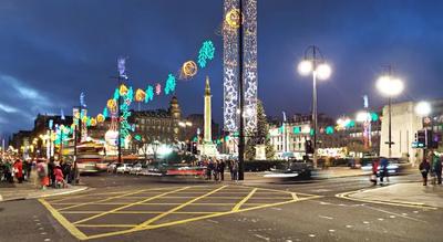 A civic square decorated with Christmas lights.