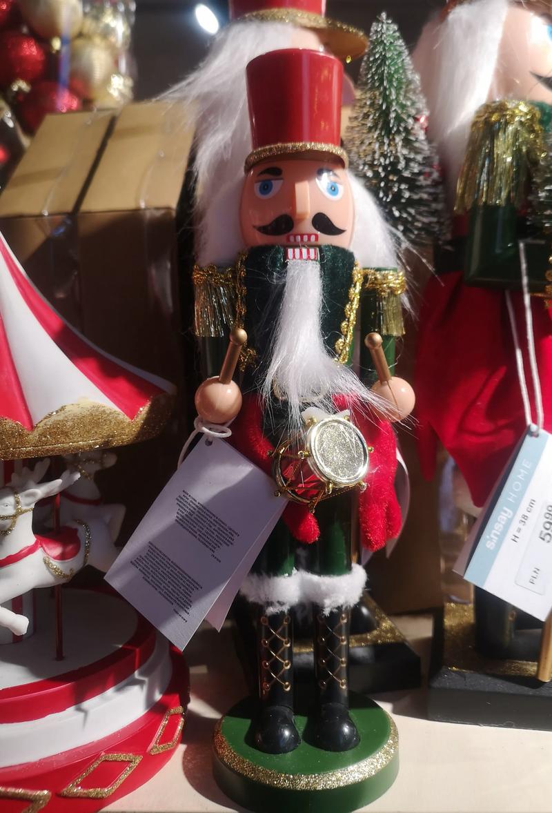 A wooden nutcracker soldier in a red coat and a tall black hat.