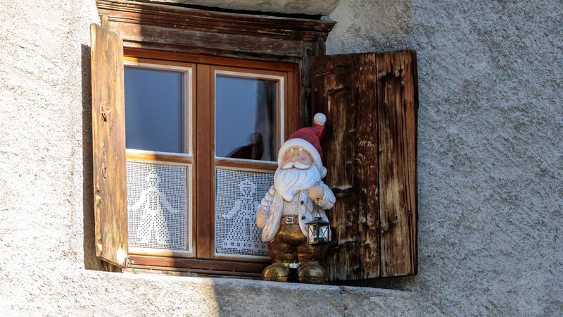 A wooden Santa figure standing in a window.