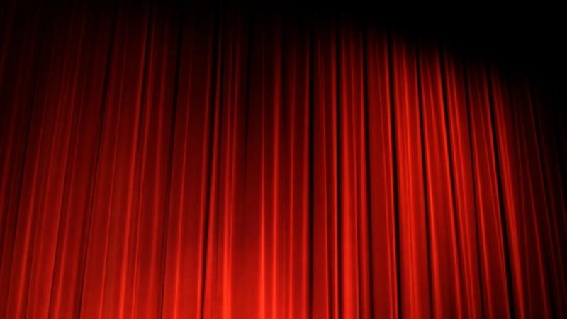 A dark stage with a lit curtain.